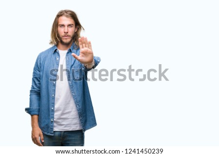 Young handsome man with long hair over isolated background doing stop sing with palm of the hand. Warning expression with negative and serious gesture on the face.