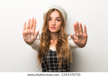 Fashionably woman wearing hat making stop gesture for disappointed with an opinion