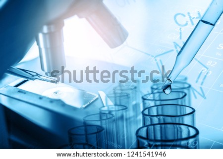microscope and dropping chemical liquid to test tubes with lab glassware, science laboratory research and development concept in blue tone. Royalty-Free Stock Photo #1241541946