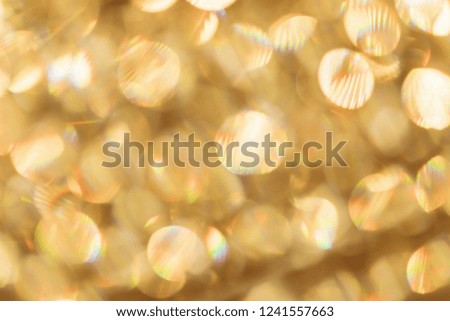 Golden glamorous abstract bokeh background. Yellow confetti like a seashell element hovering in the air effect of movement. For text holiday greetings.