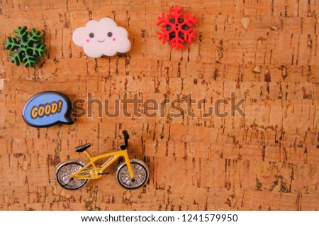 Lovely magnets as cloud snowflake good word bubble and yellow bicycle attach on magnetic board which wood color. Modern office accessories for reminder board. Colorful tone.