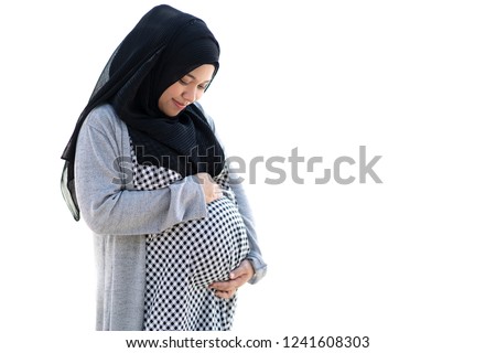 Asian muslim Indonesian pregnant woman holding hands on her belly or kid. 36 weeks of pregnant. isolate on white background. Royalty-Free Stock Photo #1241608303