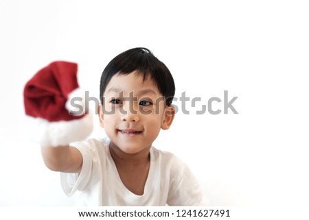 Copy space and portrait smiley Asian boy holding Santa hat. Kid pretend to Santa Claus.  White isolated Background. Concept Christmas and love, Take care and gift. Kid and Christmas party, Happiness