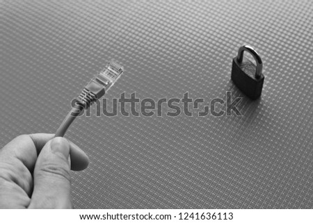 Cyber security concept image consisting of a padlock and a network cable. 