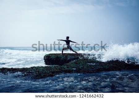 young woman practice yoga at the seaside cliff edge
