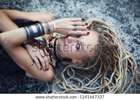Gypsy boho style young woman wearing dreadlocks and  tribal jewellery portrait