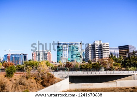 San Jose's downtown skyline as seen from the shoreline of Guadalupe river on a sunny fall day; Silicon Valley, California