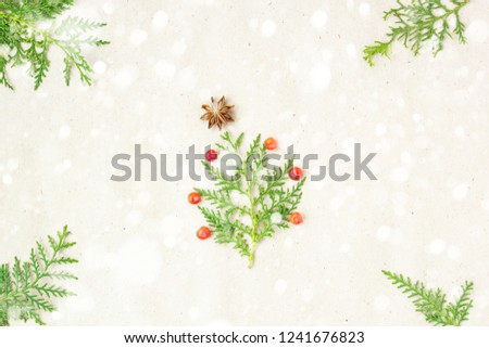 Christmas tree made of thuja branches and decorations star of anise and ashberry on snow rustic background. Christmas, new year concept. Flat lay, top view, copy space.