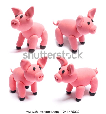 Three piglets. Cute pink pigs of plasticine on a white background.