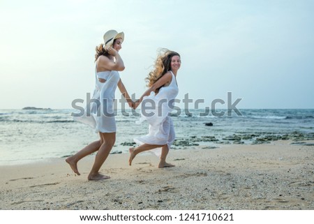 two sisters having fun at the sea at the sunset


