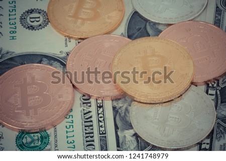 crypto currency gold silver bronzen bitcoin with dollar banknotes background