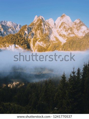 Great morning on the alpine lake Vorderer Gosausee. Picturesque foggy valley. Location place famous resort Salzkammergut, Gosau valley, Austrian alps. Dachstein glacier. Discover the beauty of earth.