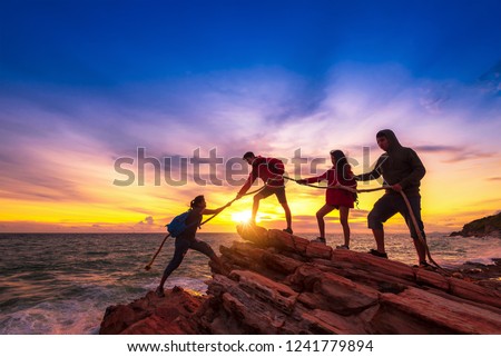Silhouette of hikers climbing up on the mountain,team work and helping concept. Royalty-Free Stock Photo #1241779894
