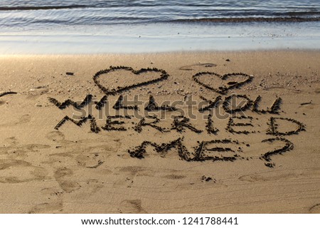 Inscription Will you merried me on wet sand.