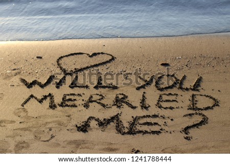 Inscription Will you merried me on wet sand.