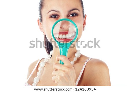 Young women playing with magnifier over her teeth