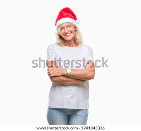 Middle age blonde woman wearing christmas hat over isolated background happy face smiling with crossed arms looking at the camera. Positive person.