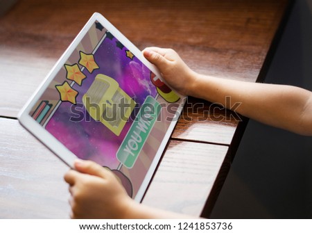 Little girl playing a game on a digital tablet