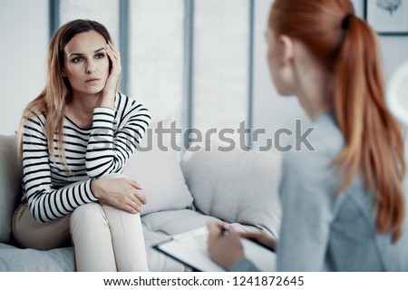 Sad business woman consulting psychiatrist about her eating disorder problems during session in office. Royalty-Free Stock Photo #1241872645