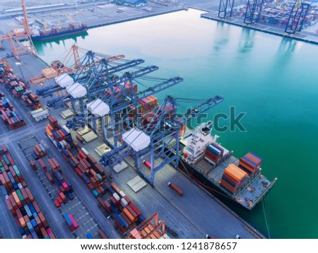 Aerial top view container ship at sea port and working crane bridge loading container for import export, shipping or transportation concept background.