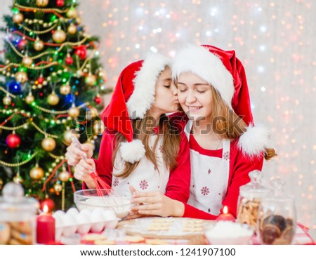 girl kissing mom while cooking Christmas dinner