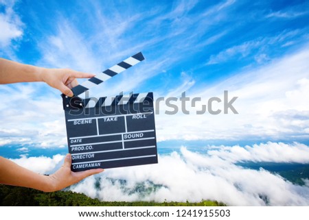 Man hands holding movie clapper.Film director concept.camera show viewfinder image catch motion in interview or broadcast wedding ceremony, catch feeling, hand hold a Film Slate with mountain and sky.