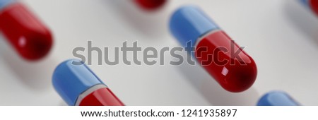 Pile of red and blue pills arranged in diagonal line on white table closeup. Life save lab food additives prescribe clinic concept letterbox view