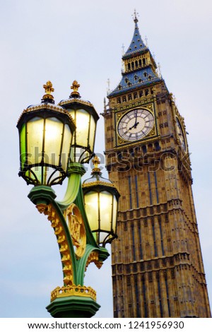 Big Ben standing tall in London with burning lanterns in front. Beatifully composed landmark in classic style. 