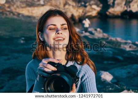 pretty woman with a camera in her hands on nature                   