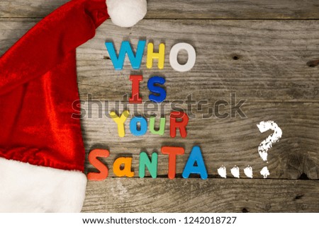 Who is your Santa question with colorful plastic letters on wooden background
