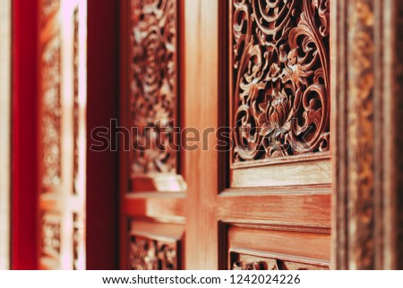 The wooden carved door of chinese temple with the shallow deprh of field, Yaowarat, Bangkok, Thailand.