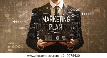 Marketing plan with businessman holding a tablet computer on a dark vintage background