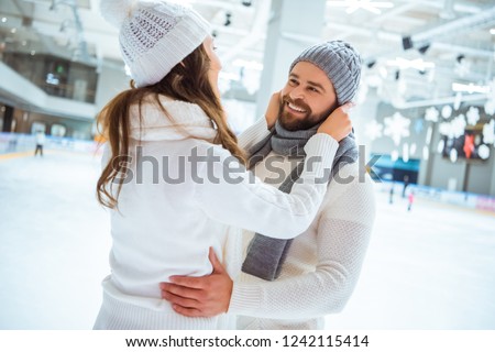 side view of smiling romantic couple on skating rink
