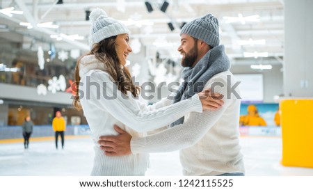 side view of smiling romantic couple on skating rink