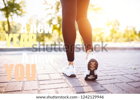 Photo of sports female legs, jogging. Image with text. New year new me. The concept of Christmas, sports, motivation.