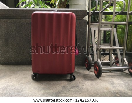 Guest luggage beside trolley on blur background in the hotel resort waiting for bellboy pick up 