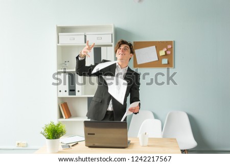 Business people, joke and fun concept - young handsome man in suit having fun in the office