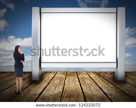 Business woman standing near blank billboard. Advertising concept.