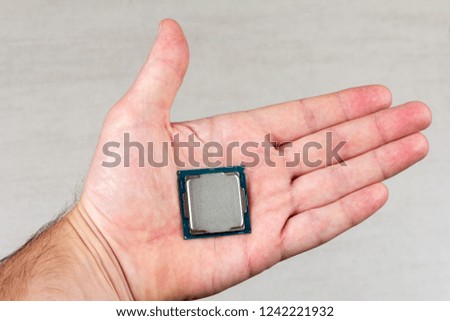 desktop processor 8th gen on a male palm on grey background closeup top view