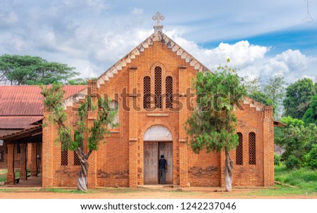 African Man stepping into the door of a little church at the Cathedral Bangui, Notre Dame, famous church in Central African Republic Royalty-Free Stock Photo #1242237046