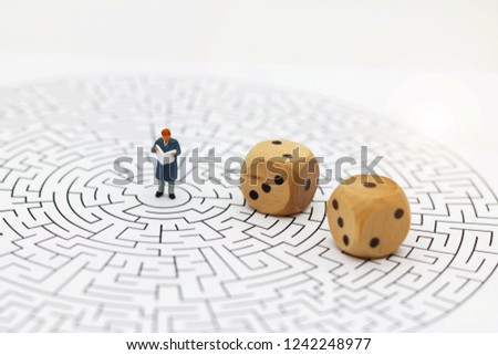 Miniature people: Businessman reading on center of maze. Concepts of finding a solution, problem solving and challenge. 