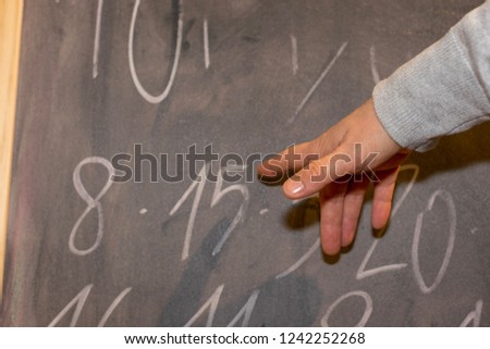 human hand pointing to a blackboard 