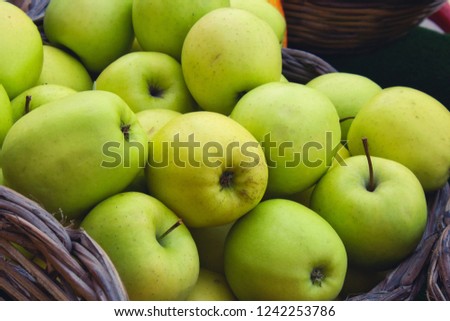 Close up of tasty green apples in a wicker basket for sale at a farmer's market