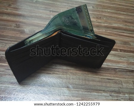 stacking Ringgit Malaysia on hand

and wallet.