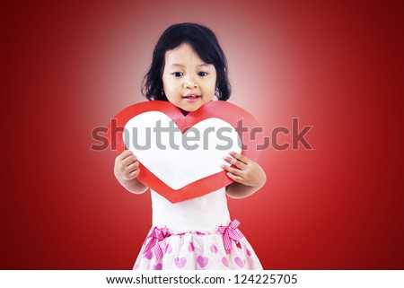 Cute girl with blank love card on red background