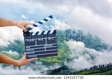 Man hands holding movie clapper.Film director concept.camera show viewfinder image catch motion in interview or broadcast wedding ceremony, catch feeling, hand hold a Film Slate with mountain and sky.