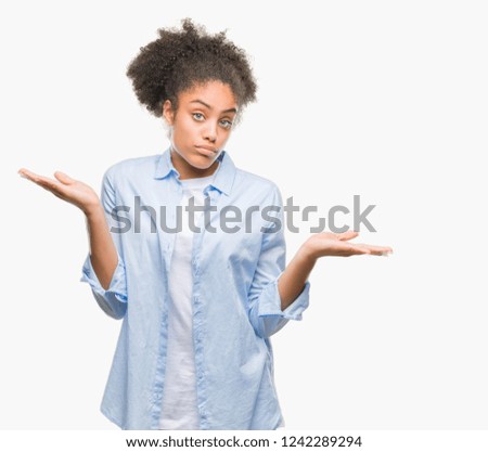 Young afro american woman over isolated background clueless and confused expression with arms and hands raised. Doubt concept.