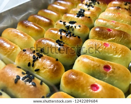 Rows of traditional chinese moon cake in oval shape with various nut cream fillings.