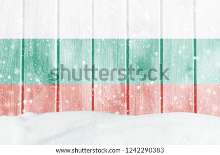 Christmas winter background with wooden wall, falling snow, snowdrift and Bulgarian flag