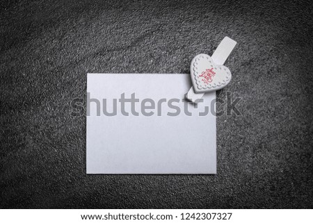 Save the Date Note Card with Love
White paper card with heart clip 
on a dark grey background isolated
